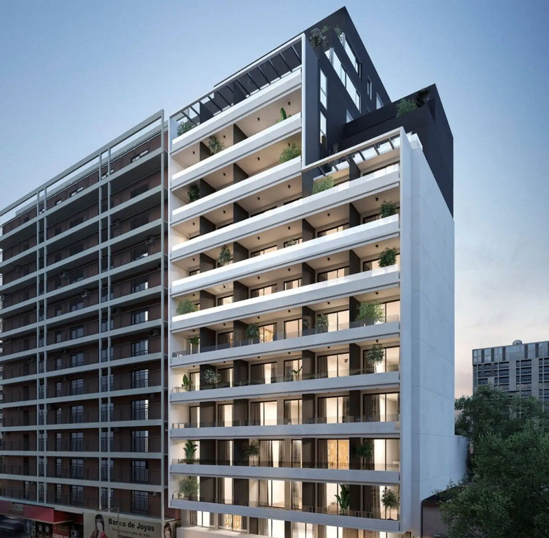 Moderno edificio residencial alto de color blanco y negro con balcones adornados con vegetación.